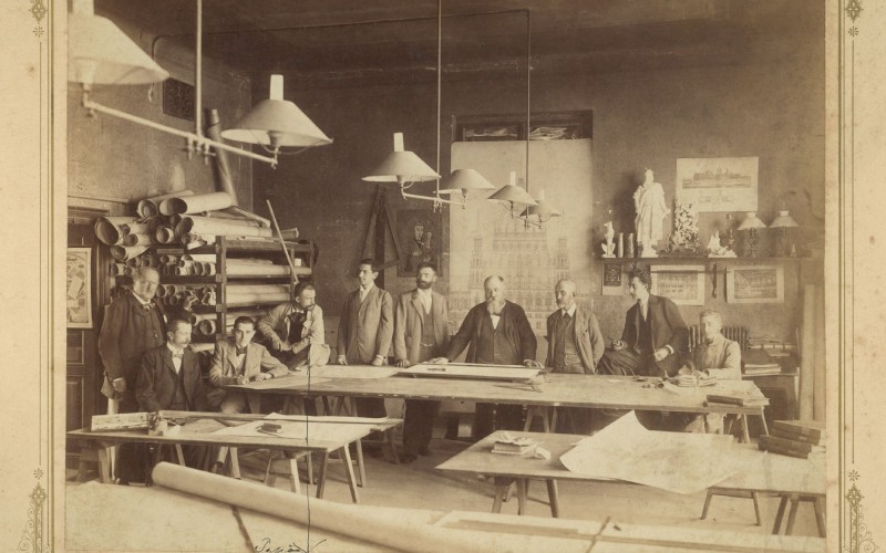 Az Országház építési irodájának rajzterme, az iroda személyzetével. Balról jobbra: Müller Károly, Galgóczy István, Wigand Ede, Foerk Ernő, Németh Lipót, Szilágyi János, Steindl Imre, Tandor Ottó, Lange Keresztély, Vásárhelyi Dezső. Divald Károly felvétele